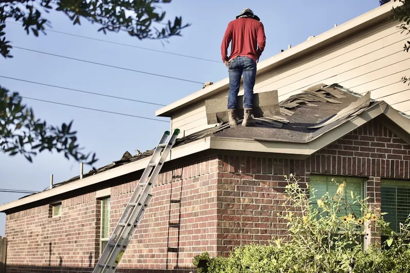 Professional roofer working on a residential roof in Saks